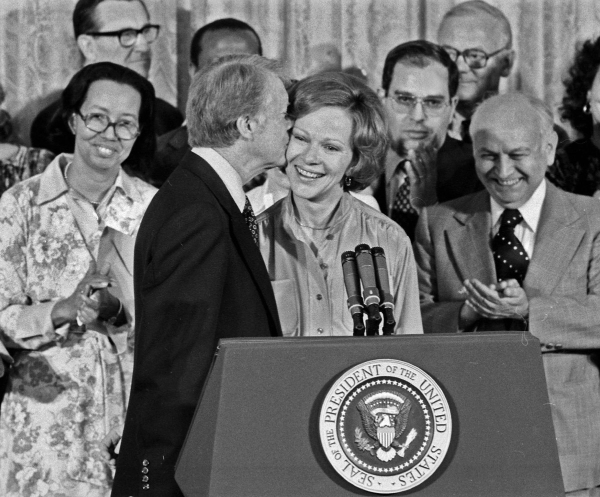 Jimmy Carter kisses Rosalynn Carter during a ceremony in which he receives the Final Report of the President’s Commission on Mental Health in 1978.