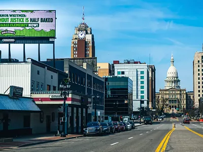 “Governor Whitmer: legalization without justice is half baked. Grant cannabis clemency now!” a billboard near the Michigan State Capitol reads.