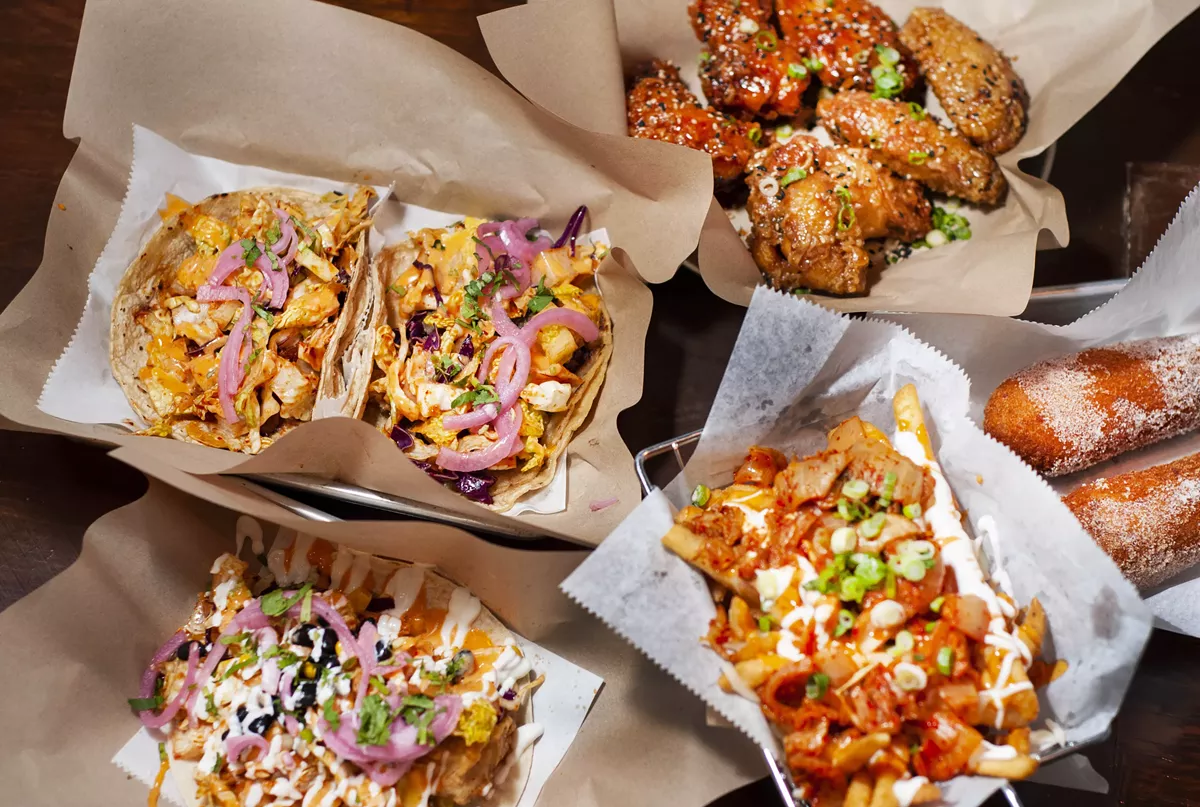 Image: From bottom left: Fish taco, bulgogi and spicy pork tacos, wings, moz dogs, and kimchi fries.