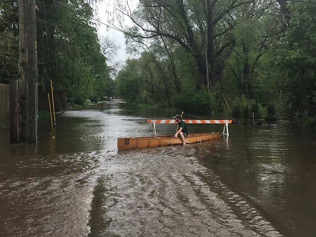 A person sits in a canoe on a Traverse City road after heavy rains flooded the area in May 2020.