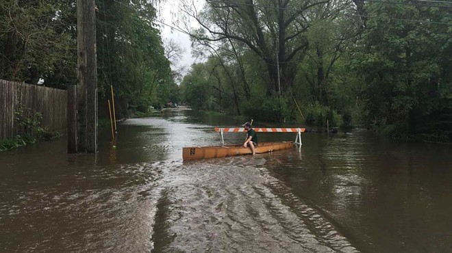A person sits in a canoe on a Traverse City road after heavy rains flooded the area in May 2020.