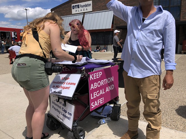 Abortion supporters sign a petition in Eastern Market in Detroit to amend the state's constitution to affirm abortion rights.