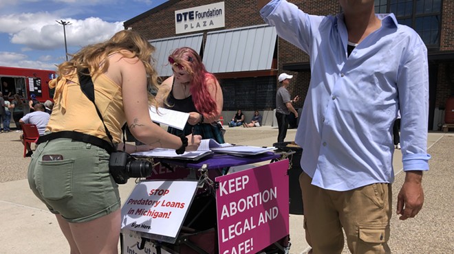 Abortion supporters sign a petition in Eastern Market in Detroit to amend the state's constitution to affirm abortion rights.