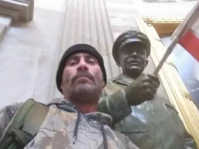 Anthony Robert Williams poses next to statue in U.S. Capitol.