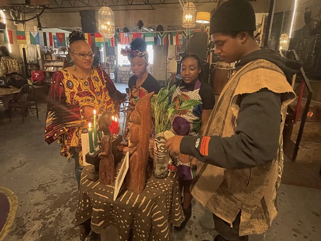 Mama Nandi (far left) and members of the Alnur African Dance group gather on the fifth day of Kwanzaa at Nandi's Knowledge Cafe.