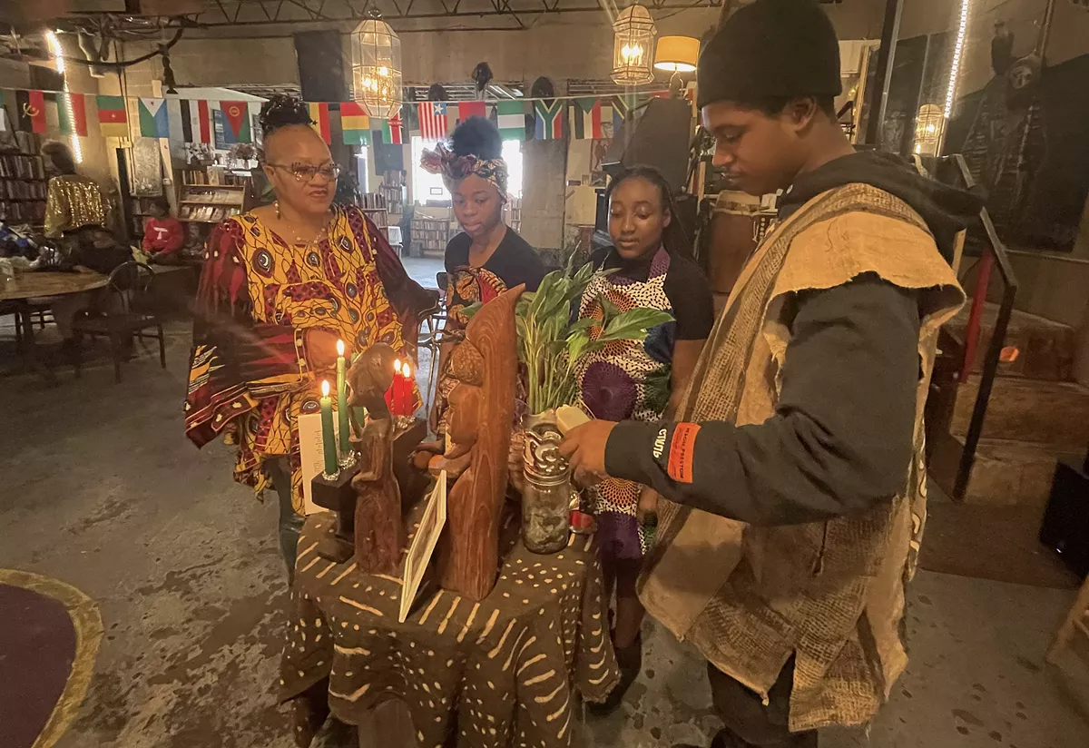 Image: Mama Nandi (far left) and members of the Alnur African Dance group gather on the fifth day of Kwanzaa at Nandi's Knowledge Cafe.