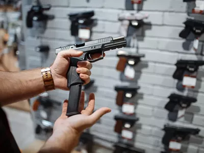 Man choosing new handgun in gun shop.