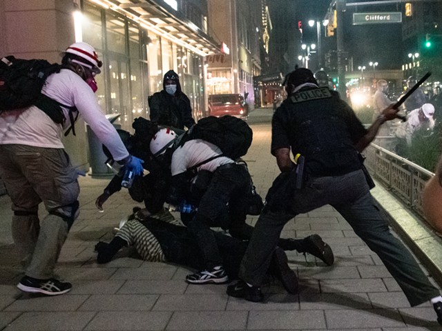Police use a baton during an Aug. 23 protest in Detroit.