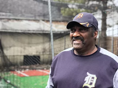 Former Detroit Tiger Ike Blessitt stands in his backyard next to a batting cage.