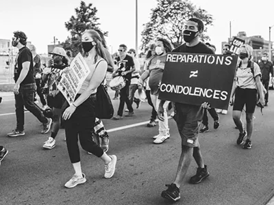 A protester in Detroit holds a sign in support of reparations.