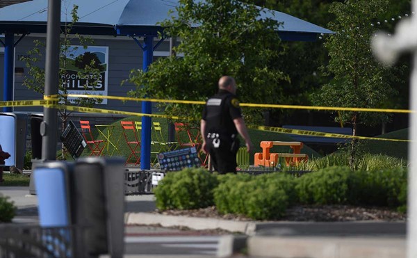A police officer walks across the plaza of the Brooklands Plaza Splash Pad in Rochester Hills, Mich., where police say there was an active shooter Saturday, June 15, 2024.