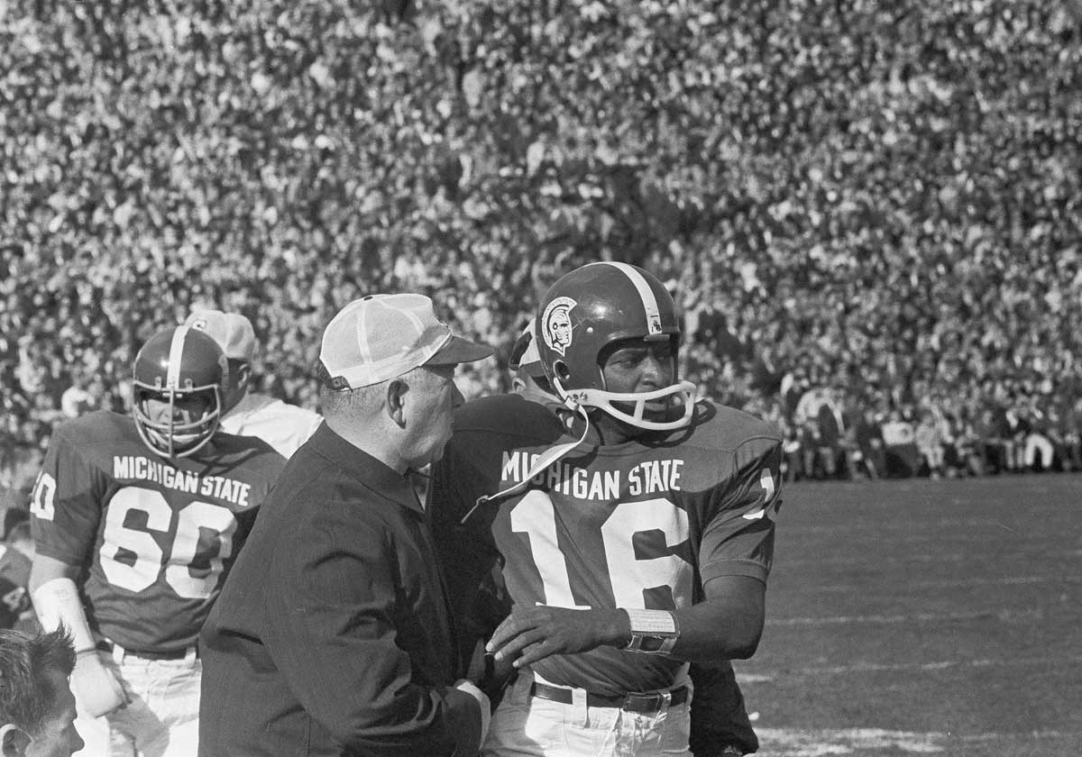 Michigan State coach Hugh “Duffy” Daugherty, left, gives last-minute instructions to quarterback Jimmy Raye before rushing him into the second quarter of the game with Purdue in East Lansing, Oct. 22, 1966.