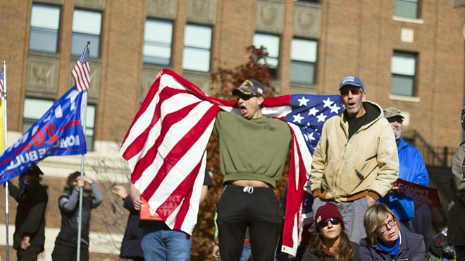Michael Joseph Foy draped in an American flag at a pro-Trump rally in Detroit in November.