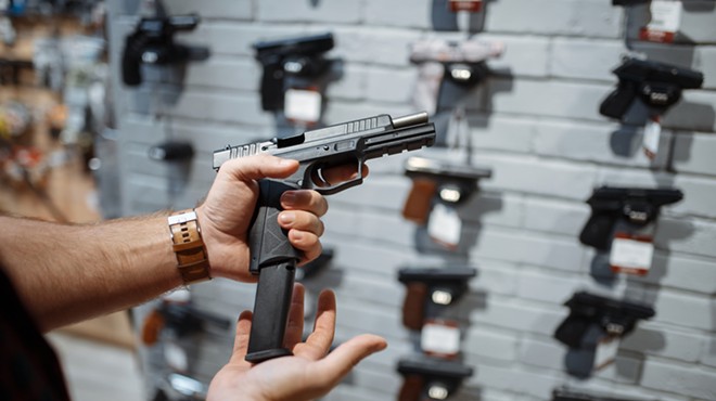 Man choosing new handgun in gun shop.