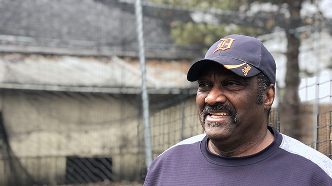 Former Detroit Tiger Ike Blessitt stands in his backyard next to a batting cage.