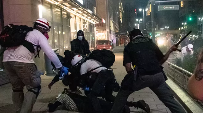 Police use a baton during an Aug. 23, 2020, protest in Detroit.