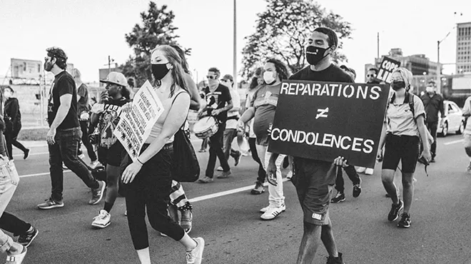 A protester in Detroit holds a sign in support of reparations.