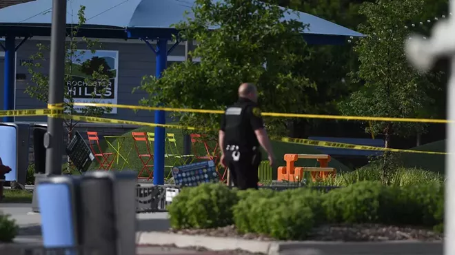 A police officer walks across the plaza of the Brooklands Plaza Splash Pad in Rochester Hills, Mich., where police say there was an active shooter Saturday, June 15, 2024.