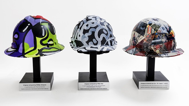 The hardhats painted by Phillip Simpson, Eric “El Cappy” Lowry, and Mike Han will benefit Downtown Boxing Gym, The Konnection, and  Junior Achievement of Southeastern Michigan.