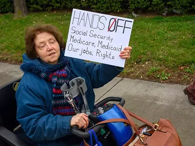 Metro Detroiters protest President Donald Trump as part of a nationwide “Hands Off!” day of action.