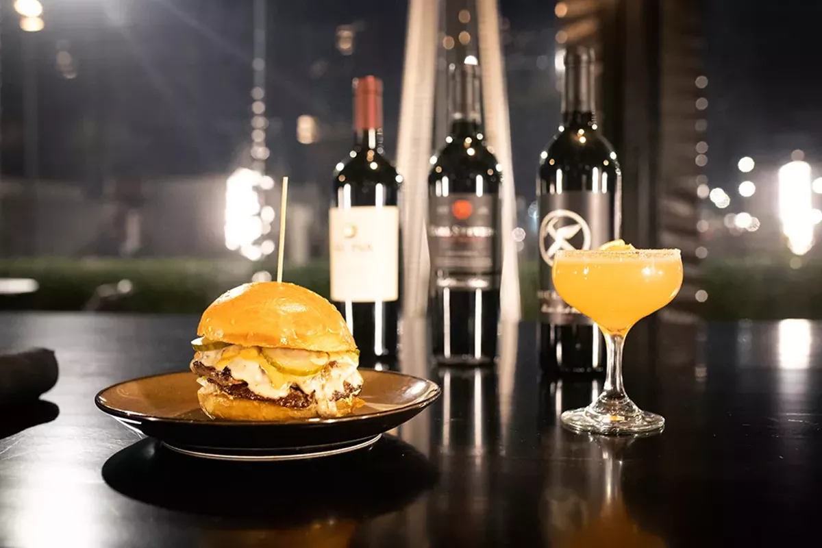 Image: The brisket burger and a cocktail from Petty Cash.