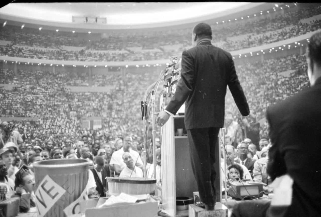Civil rights leader, Martin Luther King, Jr. stands at the podium at Cobo Hall in Detroit.