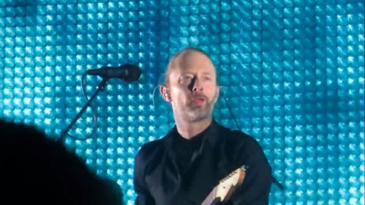 Radiohead at the Palace of Auburn Hills
June 11, 2012
Ever since Radiohead&#146;s show at the State Theater in 1997, rumors swirled that the band was boycotting the city because their gear was stolen, or the crowd was too rowdy, or they wouldn&#146;t deal with Detroit show promoters. None of that was true. According to the band, it had to do with Detroit venues reluctance to cover corporate sponsor signage and the conflict it created with Thom Yorke&#146;s desire to play in a more pure, untainted setting. The impasse finally ended in 2012 when Radiohead returned to metro Detroit for the first time in 15 years and electrified the Palace of Auburn Hills.
Photo viaYouTube screengrab
