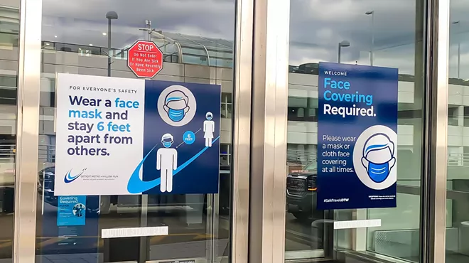 Entrance door of DTW terminal building with sign requiring masks.