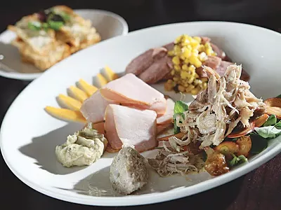 The Root's charcuterie plate: Smoked andouille sausage, pheasant confit salad, rabbit rillette, pork loin and house-made crostini.
