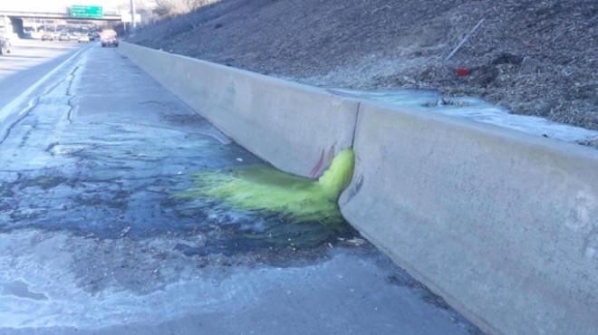 Green liquid oozing from retaining wall along I-696.