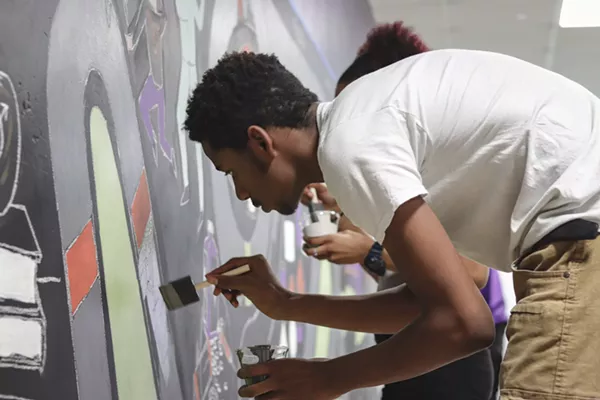 A student at Detroit's Southeastern High School, where there is no formal art program, paints a mural as part of a new partnership between the school and the Heidelberg Project. - Marshall Skeeters, Heidelberg Project