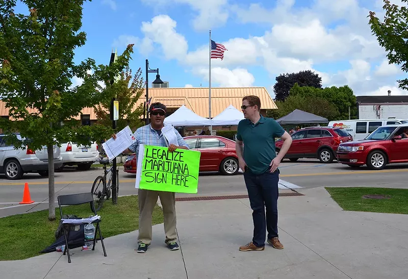 An activist encourages visitors to the National Blueberry Festival in downtown South Haven to sign a petition to legalize marijuana in Michigan. - Susan Montgomery