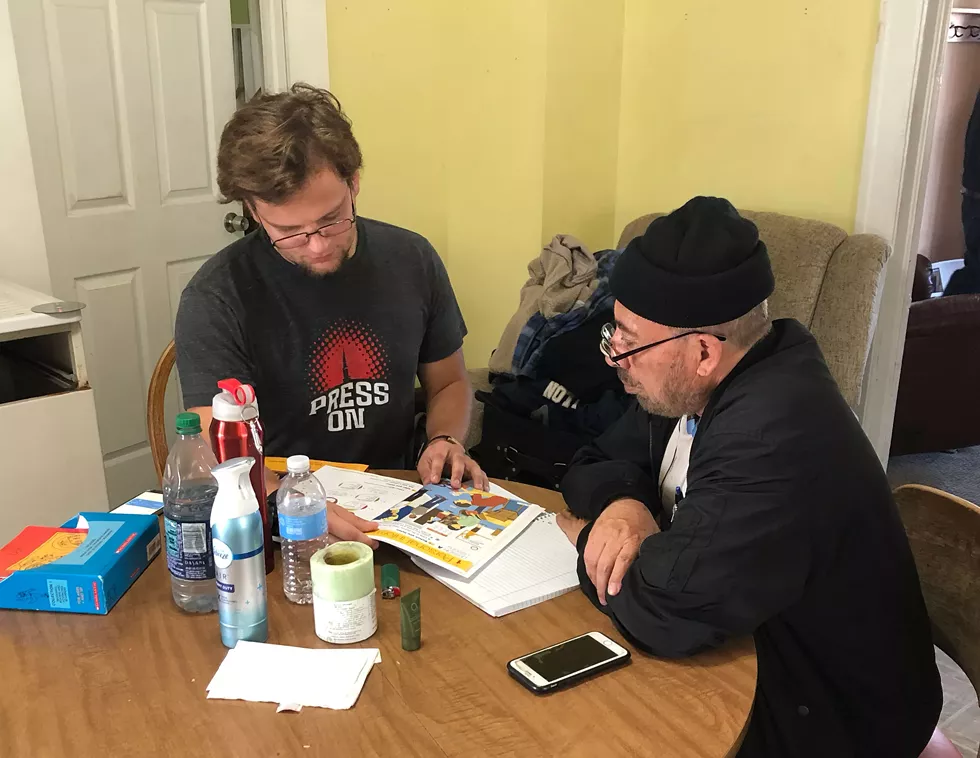 Caleb teaching a man English at Kirby's Hamtramck home. - Samuel Corey