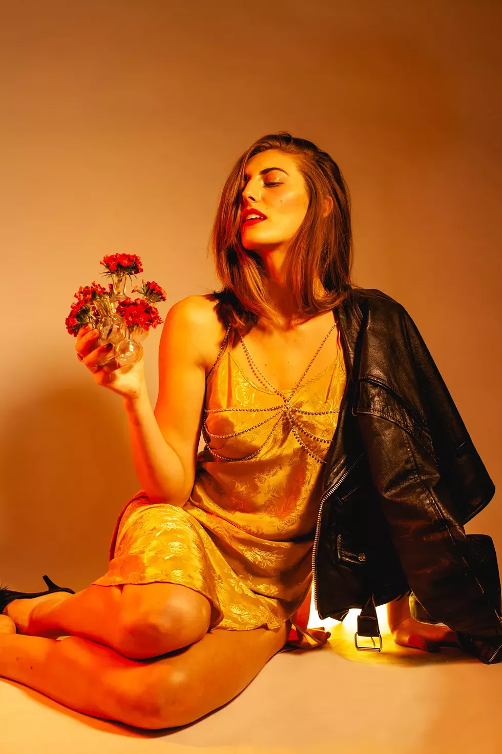 Heart-shaped box: Slip dress, $26, Flamingo Vintage, 214-538-5985; crystal rhinestone harness, $58.50, Noir Leather, 248-541-3979; noirleather.com; Gold ring, $105, Grandma’s Gold, etsy.com/shop/grandmasgoldjewelry; Acrylic pom earring, $45, Eat Da Rich, eatdarich.com; Leather jacket, vintage, writer’s own; Shoes, stylist’s own. - Miles Marie of Nomadic Madam