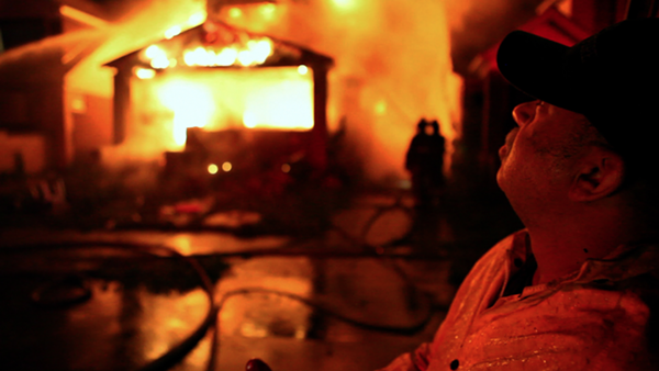 Detroit Fire Department's FEO Dave Parnell stands outside a burning home. - Burn film