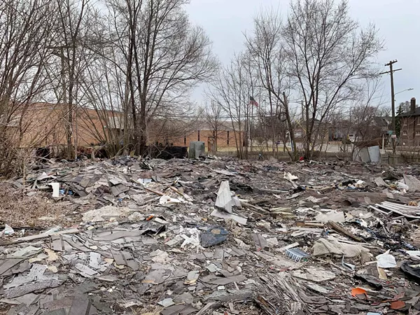 Illegal junkyard pictured with an elementary school in the background. - Tom Perkins