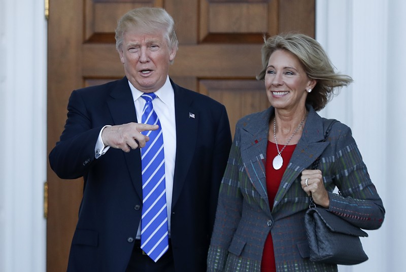 Betsy DeVos and her boss, an accused sexual predator. - SHUTTERSTOCK