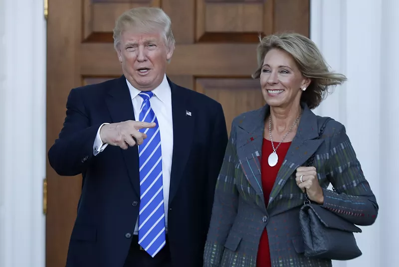 Betsy DeVos and her boss, an accused sexual predator. - Shutterstock