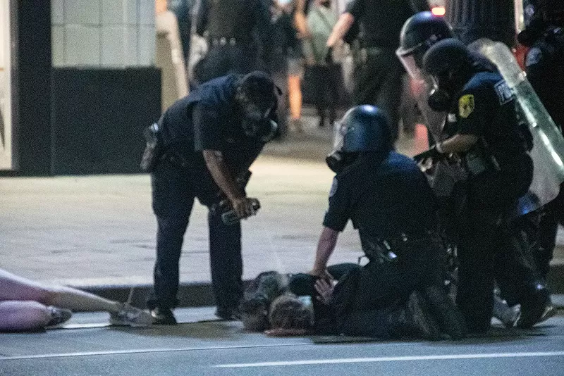 Detroit police pepper-spray a protester in the face while he's being held down. - Adam J. Dewey