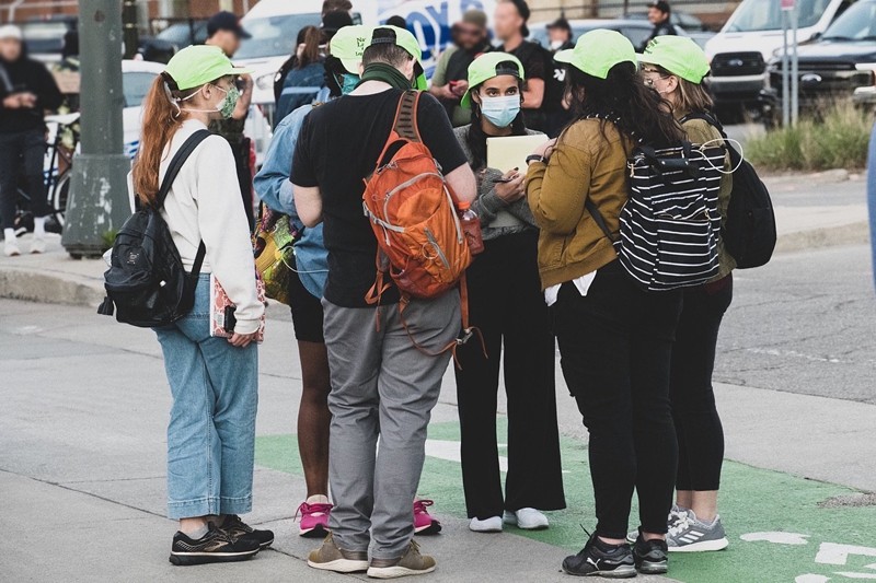 A group of legal observers from the National Lawyers Guild at a recent protest, easily identified by their bright green hats. - A.Khalid