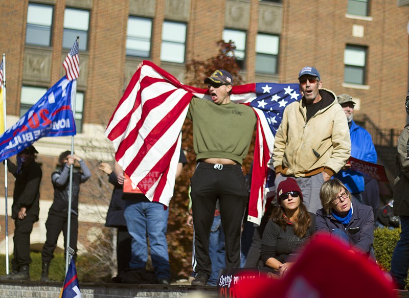 Michael Joseph Foy draped in an American flag at a pro-Trump rally in Detroit in November. - STEVE NEAVLING