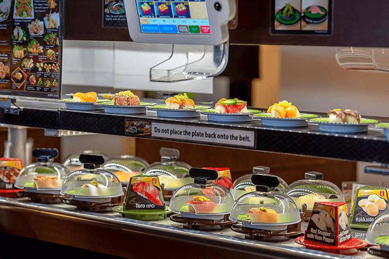 A conveyor belt delivers plates of sushito customers. - COURTESY OF KURA SUSHI