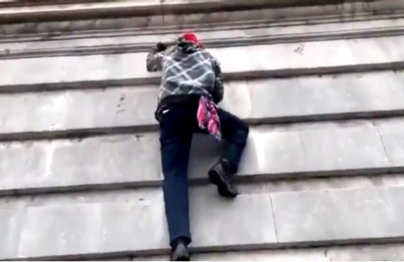 Jeramiah Caplinger scaling a wall at the U.S. Capitol. - FBI