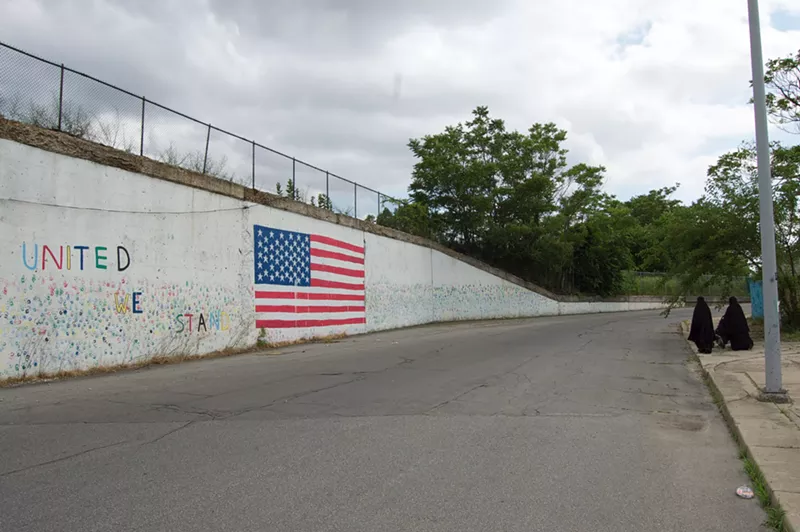 Muslim women walking near an American flag mural in Hamtramck, Michigan. - Lee DeVito