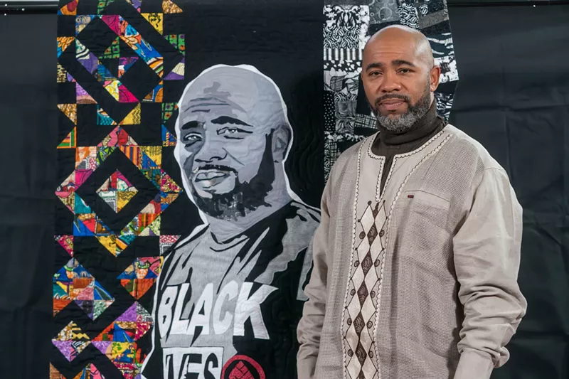 Dwan Dandrige next to the quilt inspired by his time growing up in Brightmoor. - Live Coal Gallery, LLC