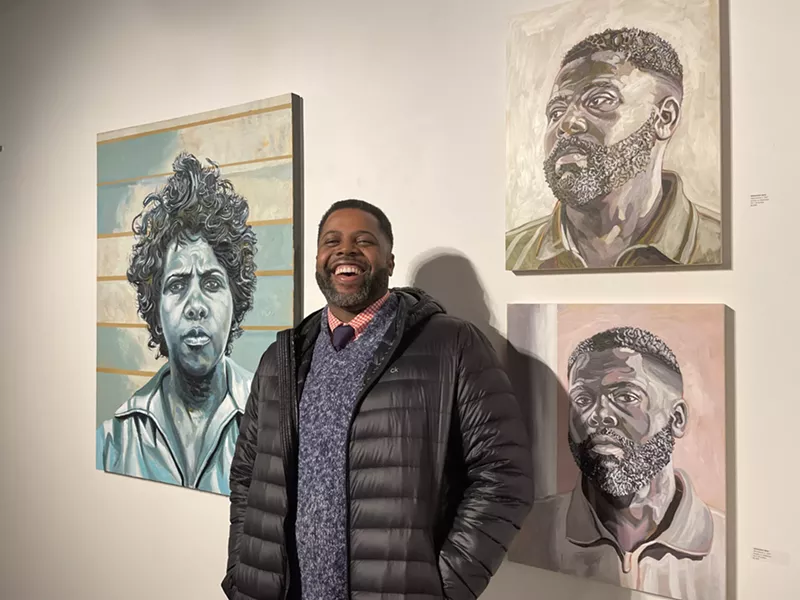 Artist Senghor Reid next to his paintings at the Revelations exhibit. - Randiah Camille Green