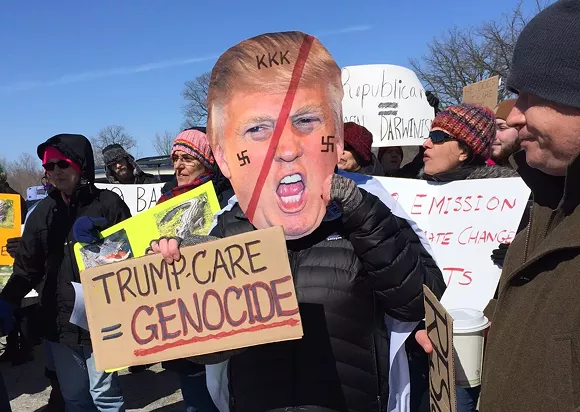 Protesters gather outside President Donald Trump's stop at the American Center for Mobility in Ypsilanti Township.