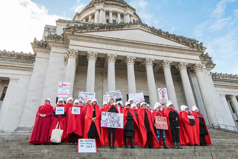 Abortion rights activists dress up as characters from The Handmaid's Tale at a protest. - Phil Lowe/Shutterstock.com