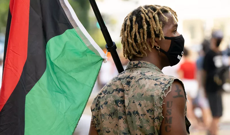 A person with a Pan-African flag. - Victoria Pickering, Flickr Creative Commons