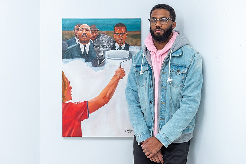 Harris with his "Critical Race Theory" painting.  - TAFARI STEVENSON-HOWARD